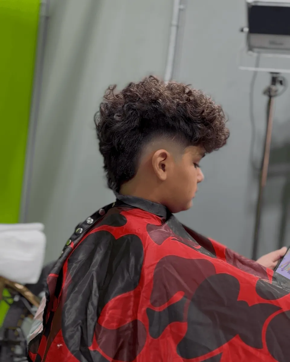 Curly textured top with a fade at Blades Vision Barbershop in Houston, TX