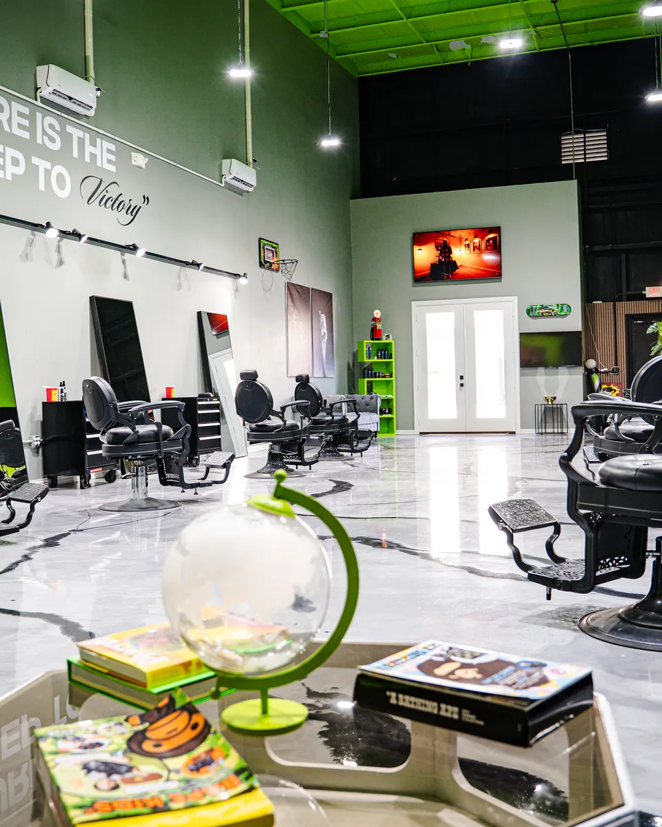 Inside Blades Vision Barbershop in Houston, TX — barber chairs and green accent walls